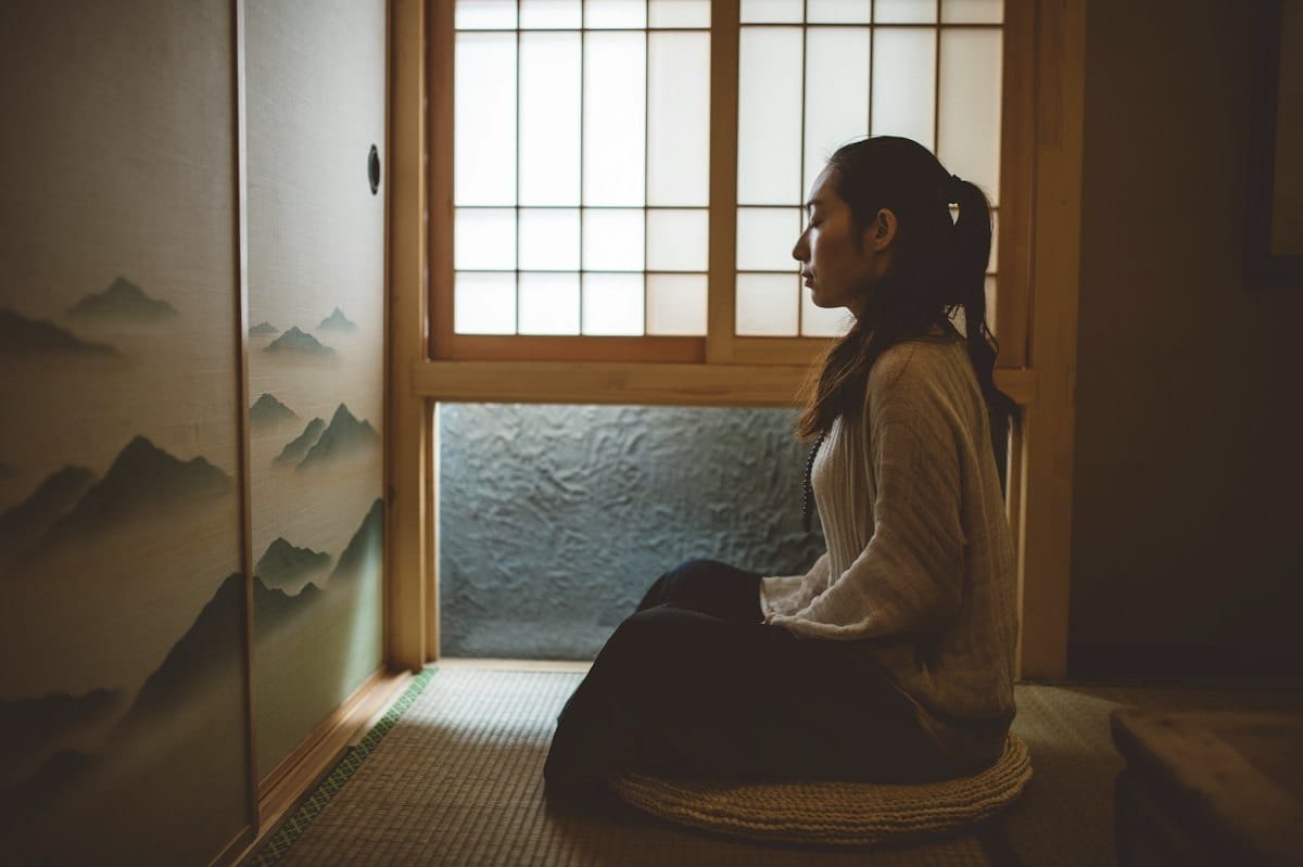 Person sitting quietly in meditation practising slow breathing during a panic attack